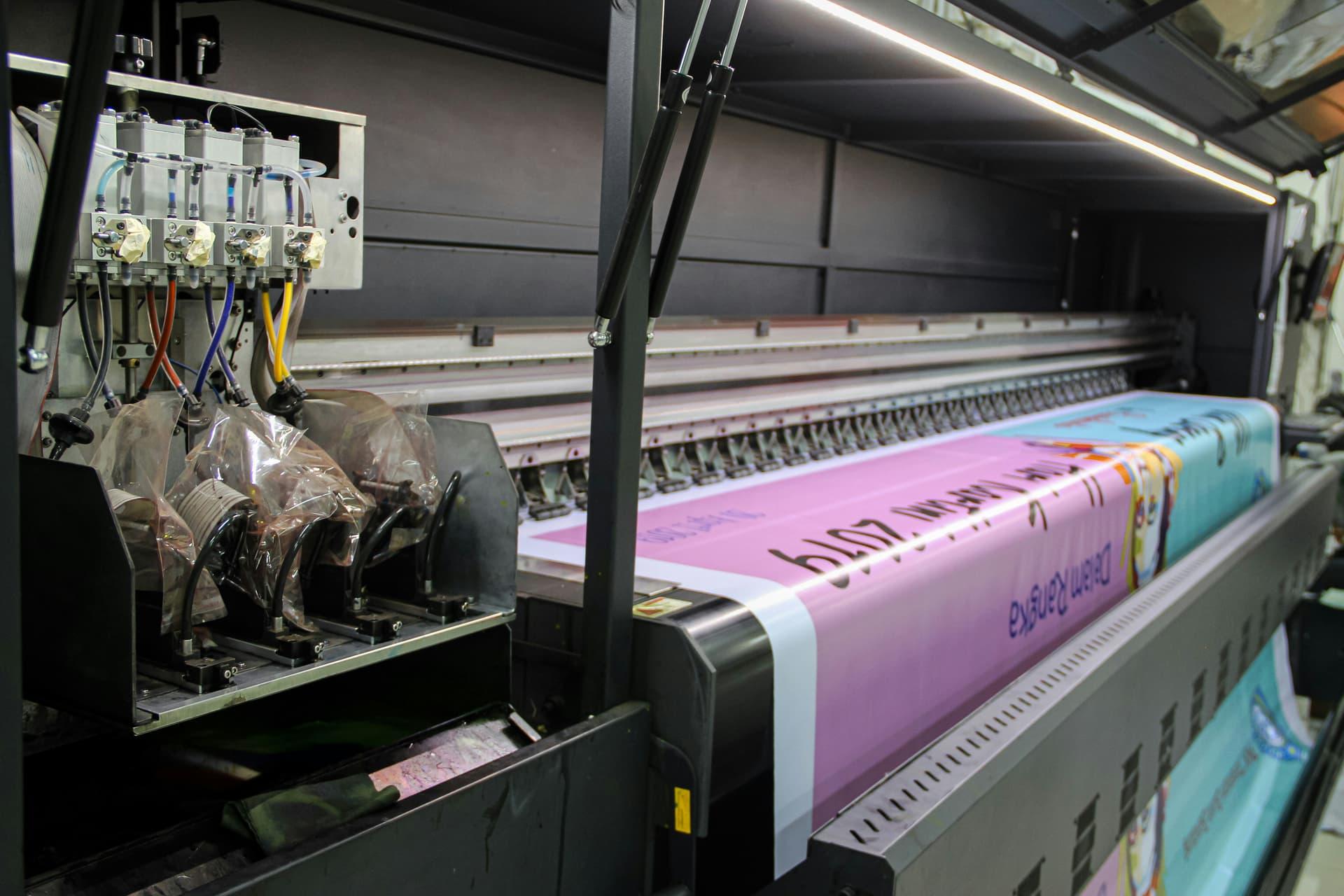 Large format digital printer producing vibrant color prints at Quality Print Center FIU